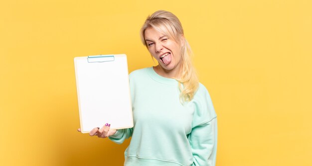 Blonde woman with cheerful, carefree, rebellious attitude, joking and sticking tongue out, having fun