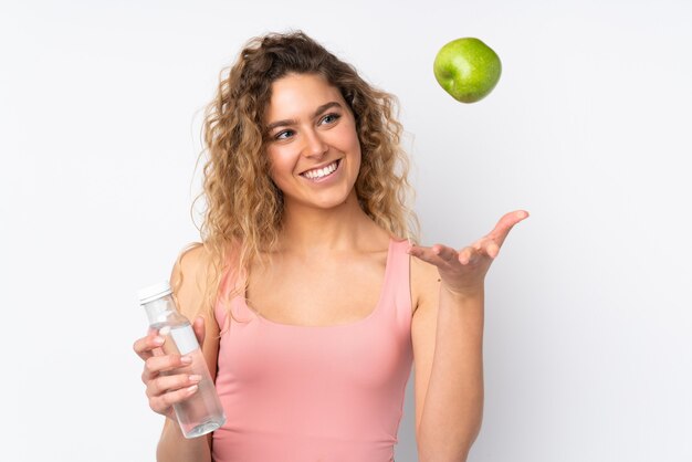 blonde woman with curly hair isolated with an apple and with a bottle of water