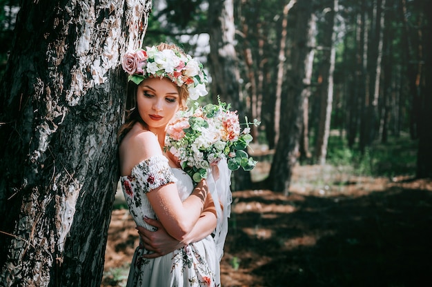 緑の森の花のスタイルとブロンドの女性