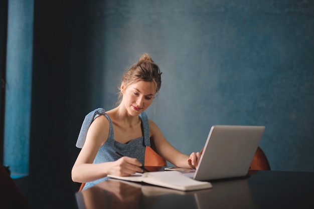 Foto donna bionda che lavora ad un computer portatile