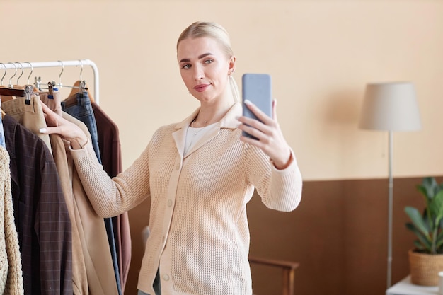 Blonde young woman recording fashion blog