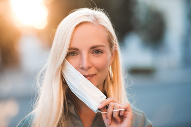 blonde young woman wearing medical protective mask
