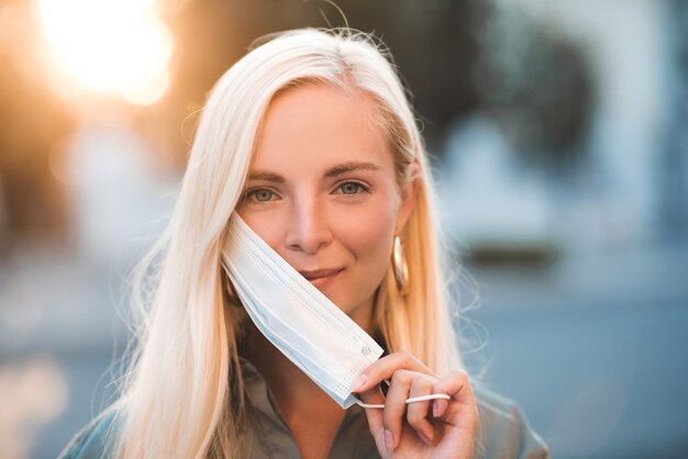 Blonde young woman wearing medical protective mask