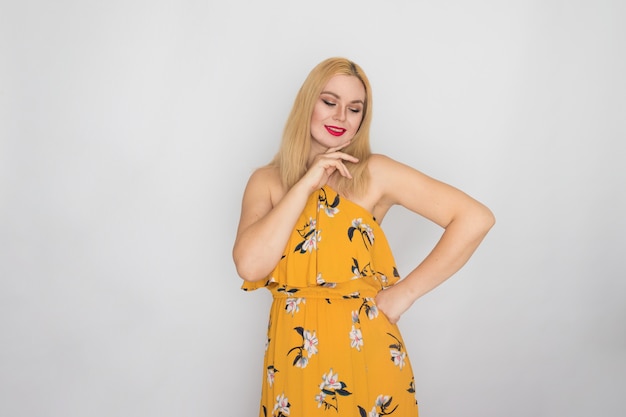 Блондинка молодая женщина в желтом цветочном весенне-летнем платье