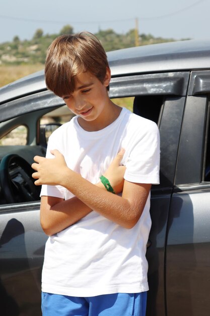 Blonde Youth Boy in White Shirt and Blue Shorts Enjoying Summer Sun in Nature