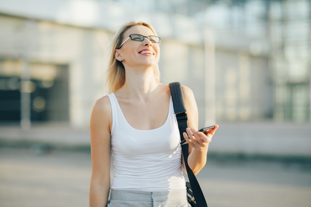 Blonde zakenvrouw leest een bericht op de telefoon