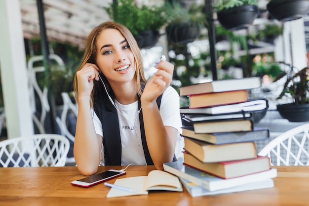 Blonde zakenvrouw met boeken op kantoor