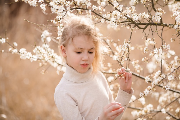 Blondemeisje in de bloesemtuin.