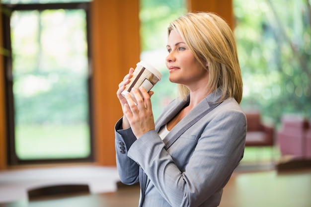 Blondeonderneemster die een koffie hebben