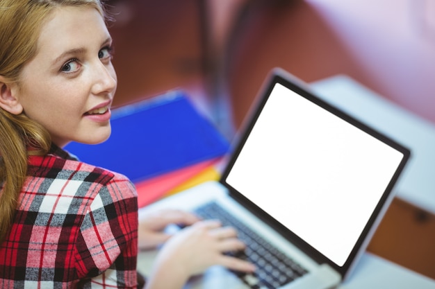 Foto blondestudent die laptop met behulp van tijdens klasse