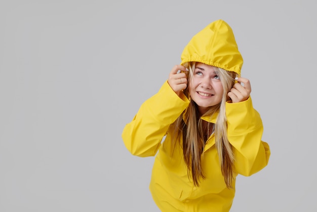 Blondevrouw die gele regenjas dragen