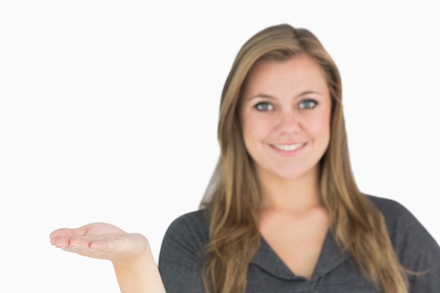 Foto blondevrouw die met haar hand voorstellen