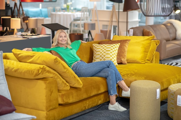 Blondevrouw in een groene blouse die goed voelen