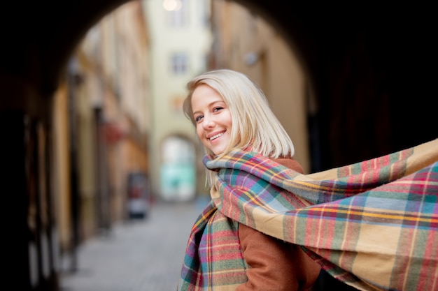 Blondevrouw met sjaal in oude stad van Wroclaw