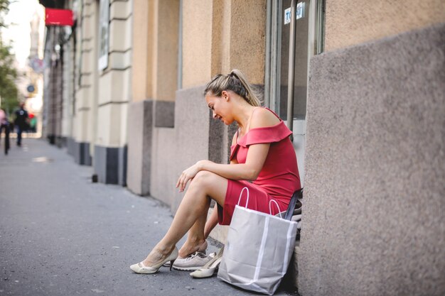 Blondevrouw veranderende schoenen op de straat