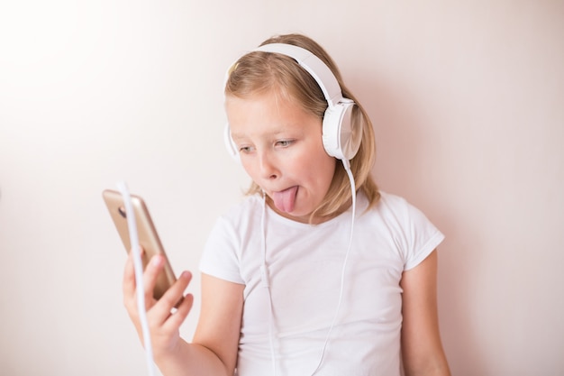Блонди девочка-подросток с наушниками, слушать музыку
