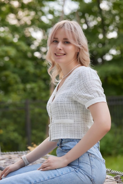 Blondie giovane ragazza in abito nero con capelli lunghi ritratto all'aperto donna caucasica abbastanza allegra