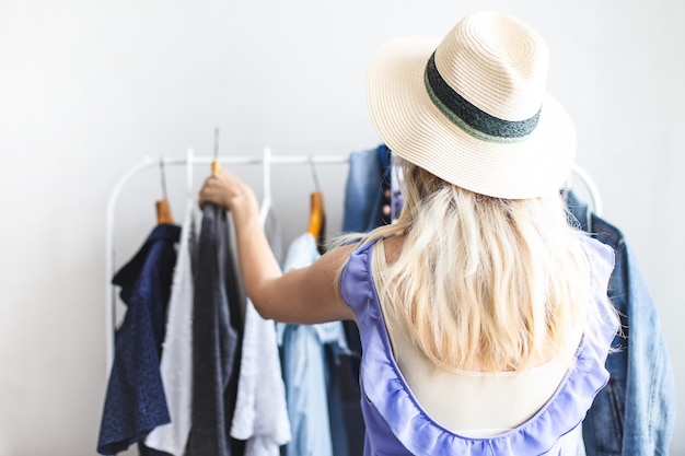 Blondy girl near a wardrobe with clothes