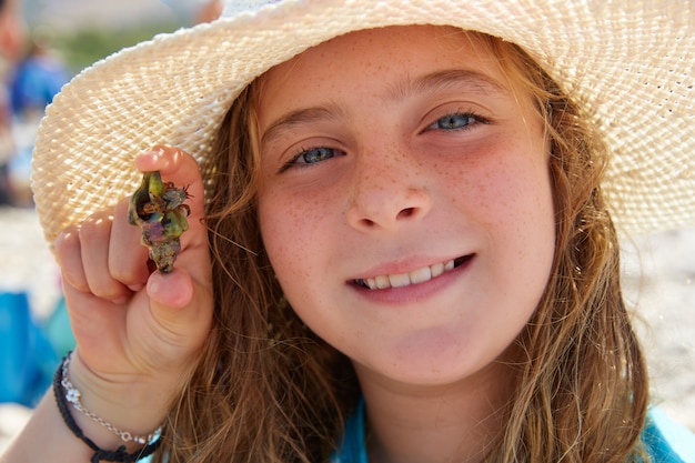 Blonk kid girl holding hermit crab