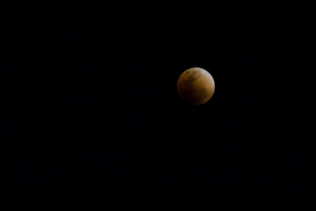 Foto concetto di luna piena di sangue di una luna piena rossa contro un cielo nero