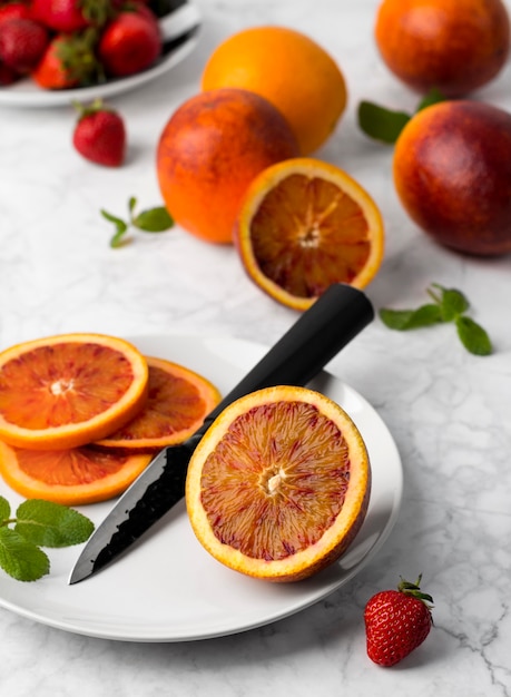 Blood orange slices on the plate with mint leaf and knife