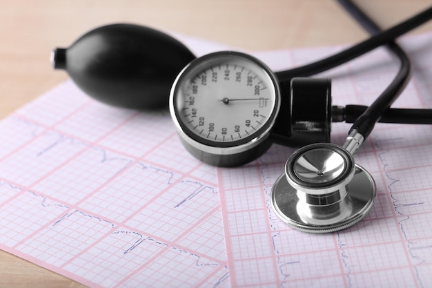 Blood pressure meter digital tablet and stethoscope on wooden background