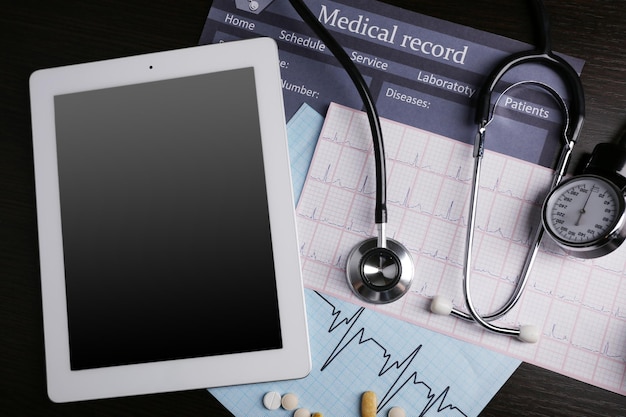 Photo blood pressure meter stethoscope digital tablet on dark background