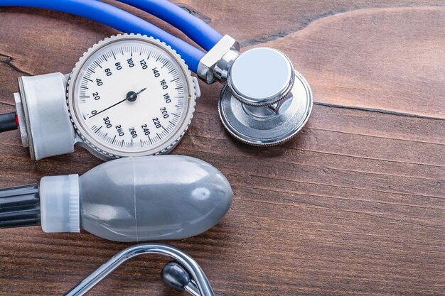 Blood pressure monitor and stethoscope on vintage wooden board