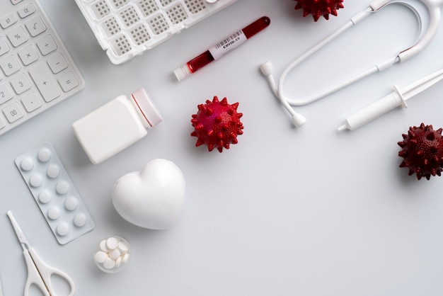Образец крови, миниатюры коронавируса и медикаменты