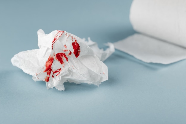 Blood on tissue paper on white background. Health medical treatment concept.