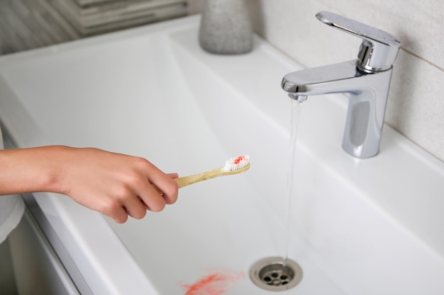 Blood on toothbrush on background of sink Selective focus on the toothbrush