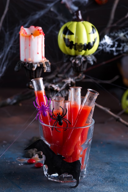 Cocktail sanguinante in tubi di vetro per la celebrazione della festa di halloween.