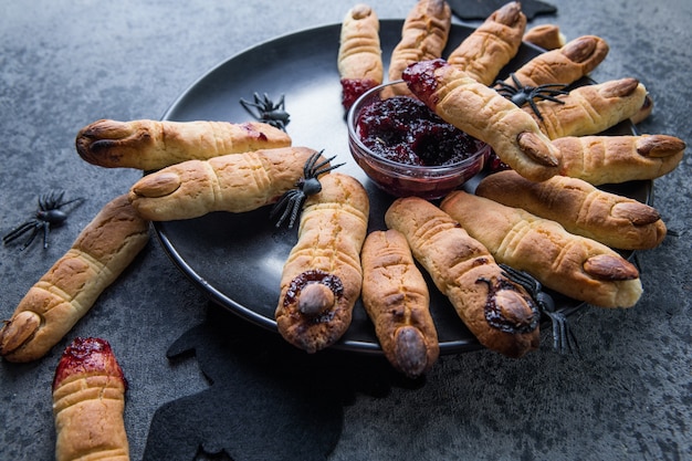 Bloody  cookies fingers for Halloween party celebration, Cookies "Witchs fingers". Dark background, food for Halloween