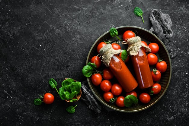 Bloody Mary cocktail in a bottle Two bottles of tomato juice Cherry tomatoes Top view On a stone background