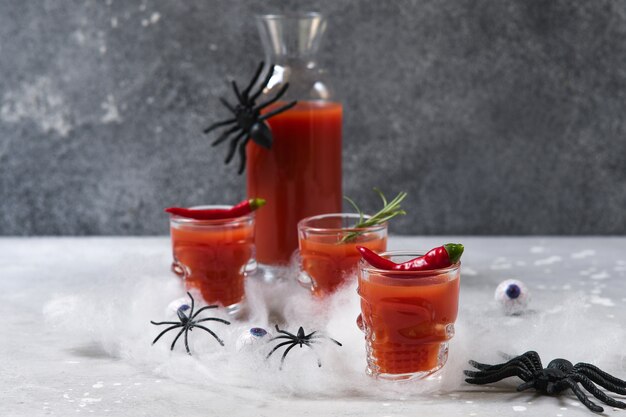 Bloody mary cocktail or tomato juice in glasses shaped like skulls