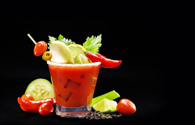 Bloody mary een rode drank op basis van wodka tomatensap citroensap selderij erwten Worcestershire saus tabasco en peper op een zwarte achtergrond geïsoleerde zwarte achtergrond en kopie ruimte