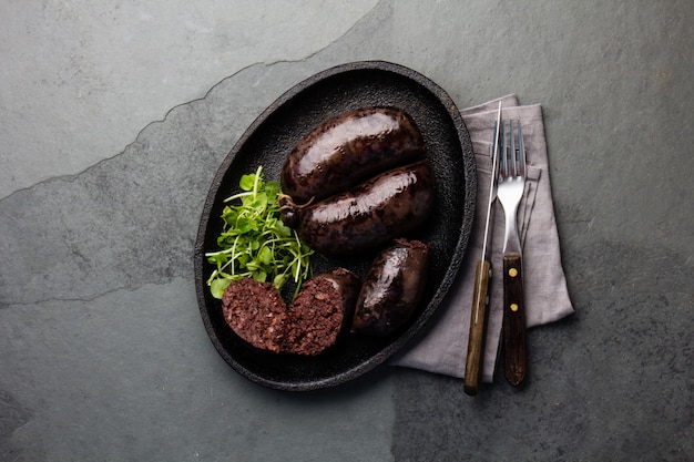 Bloody sausages on an iron plate