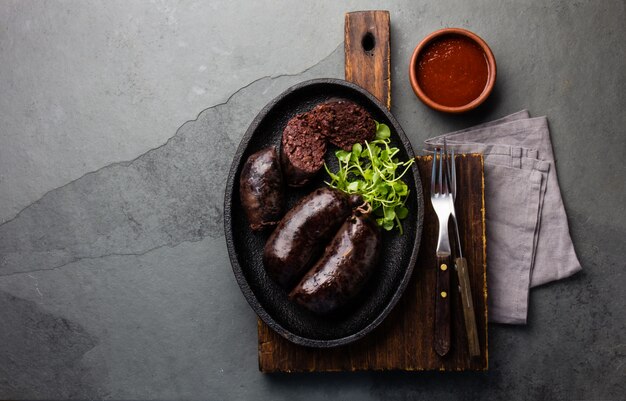 Bloody sausages on an iron plate