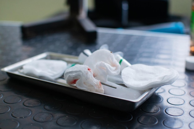 Bloody used cotton pads at the iron box Close up view of the veterinarian clinic Healthcare and medicine concept