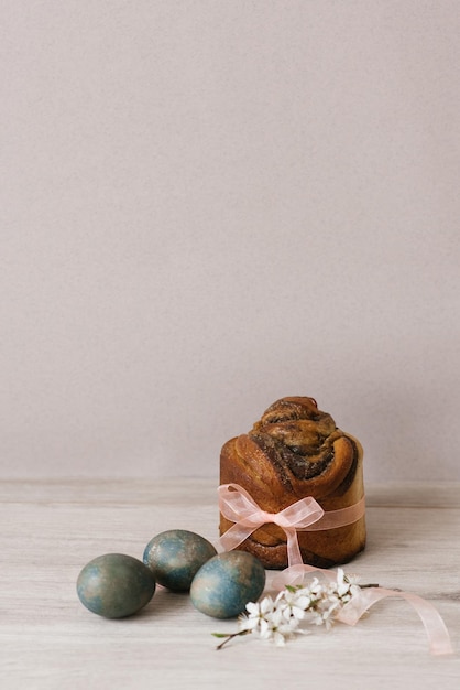 Blooming apple tree branch and Easter cake painted with eggs on the table