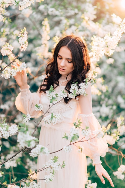 A blooming garden with a beautiful young woman in it