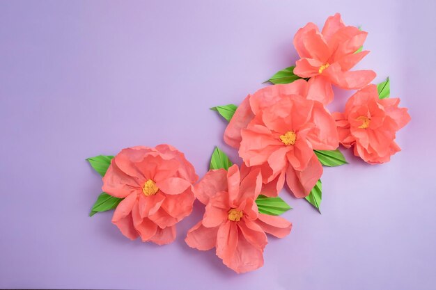 Blossom of a pink rose paper flowers on lilac pastel color background with space diy craft decor