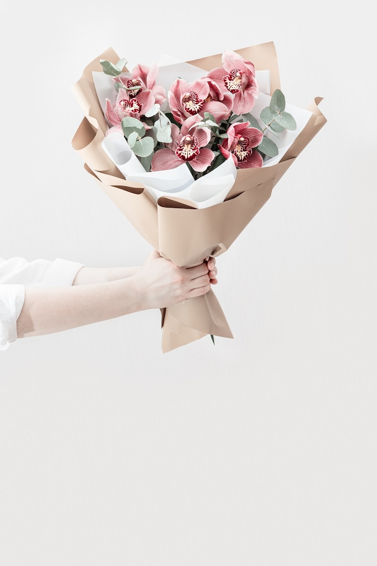 Photo 여성의 손에 분홍색 난초의 꽃이 만발한 섬세한 꽃 꽃다발