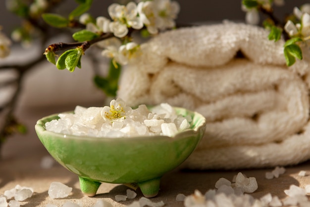 Blossoming plum tree branch, aromatic sea salt and towels.