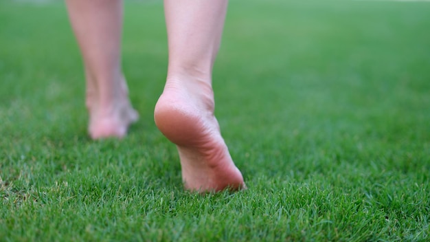 Blote voeten lopen op groen gras in de ochtend close-up