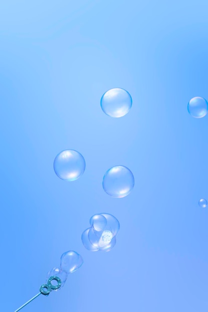 Blowing soap bubbles on blue background