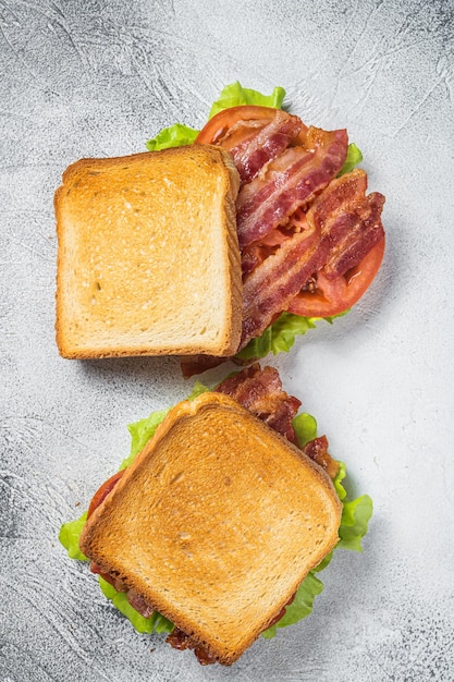 베이컨, 토마토, 양상추를 곁들인 BLT 토스트 샌드위치. 회색 배경입니다. 평면도.