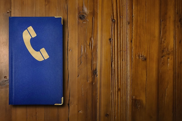 A blue address book on a wooden desk