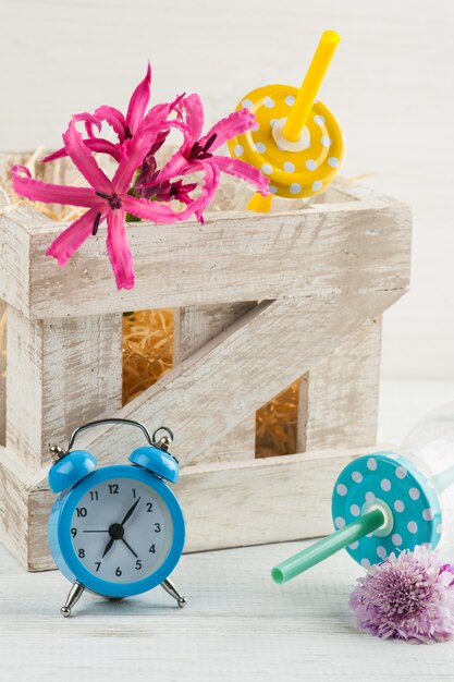 Blue alarm clock, bottles with pink lilly