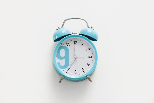 Blue alarm clock on the white background. Morning, time to wake up.